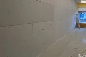 Drywall sheets being hung on new framing